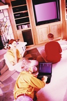 Family using technology: phone, laptop, TV